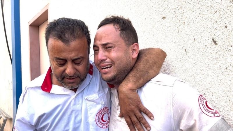 محمود (على اليمين) مع زميله، خلال اللحظات المؤلمة التي تلت اكتشافه مقتل والده - بي بي سي